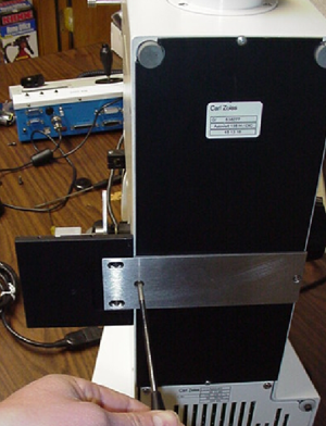 Figure 3: Set the scope on its back and remove the two center baseplate screws as shown.  Use the two 3 x 10 mm flat head screws to attach the ASI baseplate as shown
